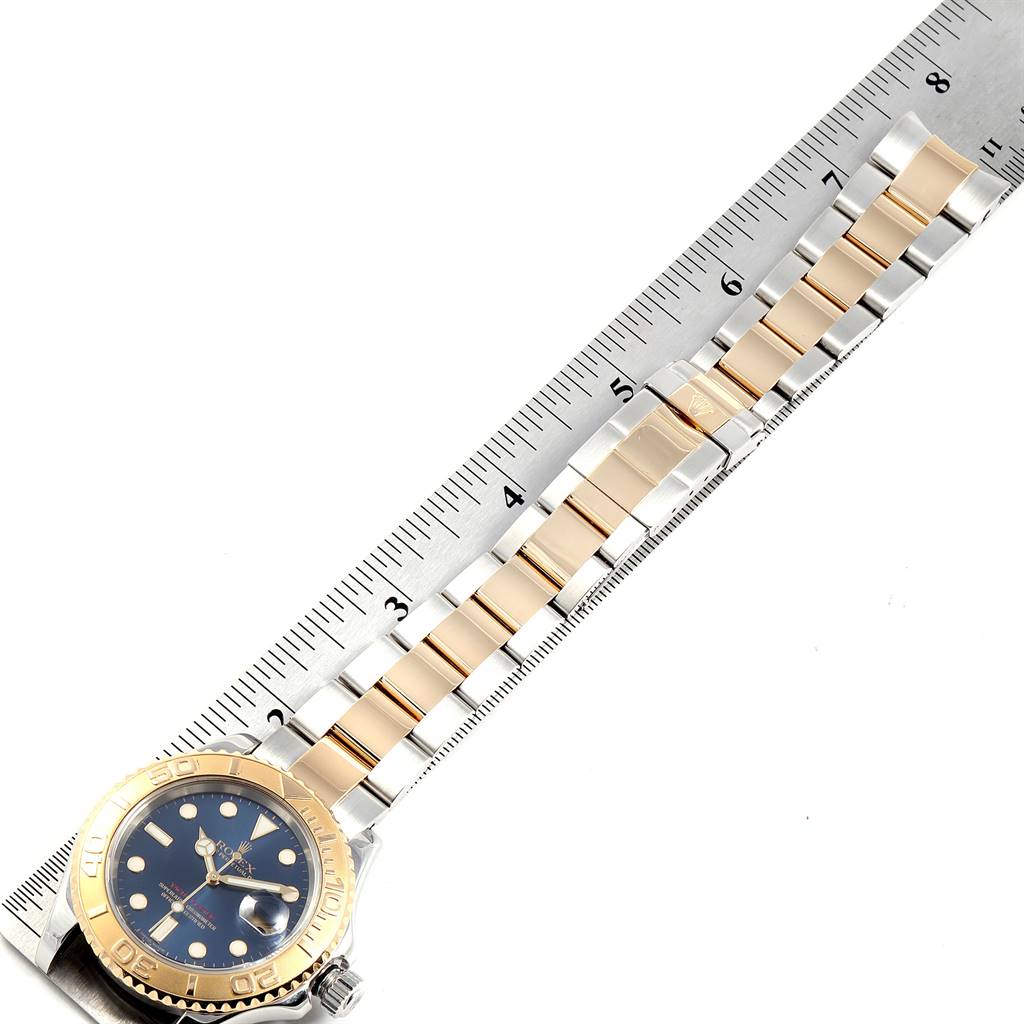 The image shows the Rolex Yacht-Master 16623 Men's Stainless Steel Blue Dial 16623 Men's Stainless Steel Blue Dial watch lying flat with a focus on its strap and face, alongside a ruler for measurement.