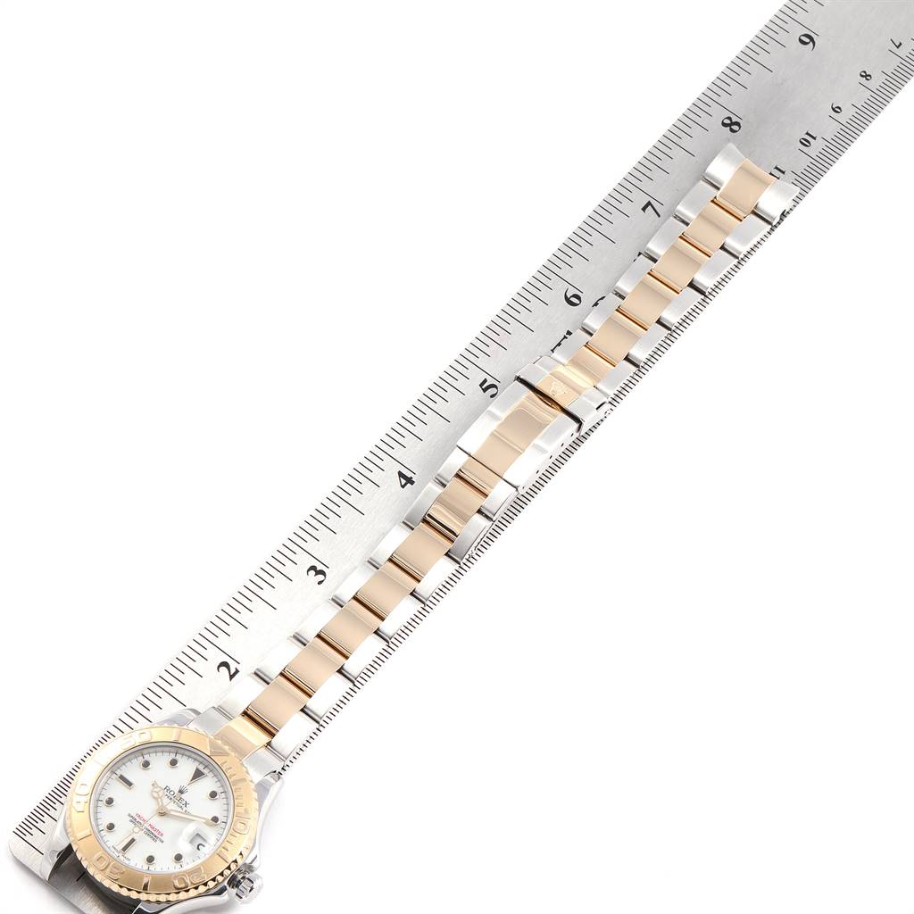 The Rolex Yacht-Master 168623 Men's Steel and Gold (two tone) White Dial 168623 Men's Steel and Gold (two tone) White Dial watch is shown from top view, featuring its dial and metal strap alongside a measuring ruler.