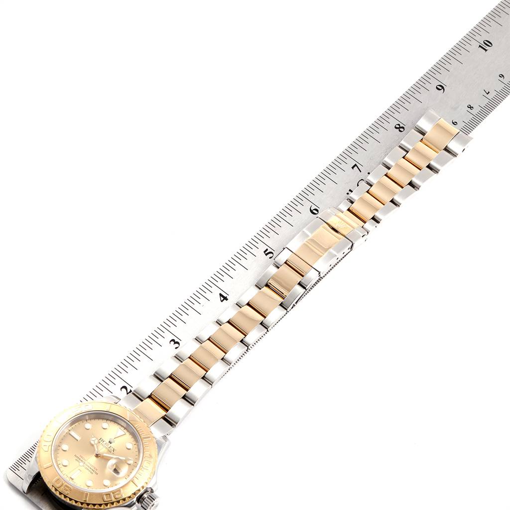The image shows a Rolex Yacht-Master 16623 Men's Stainless Steel Champagne Dial 16623 Men's Stainless Steel Champagne Dial watch placed next to a ruler, emphasizing the bracelet and face at an angled top-down view.