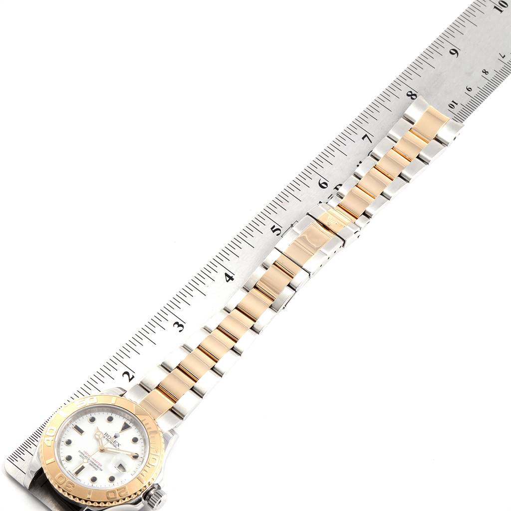 The Rolex Yacht-Master 16623 Men
s Stainless Steel White Dial 16623 Men
s Stainless Steel White Dial watch is shown from an overhead angle, highlighting the face, bezel, and full bracelet against a ruler.