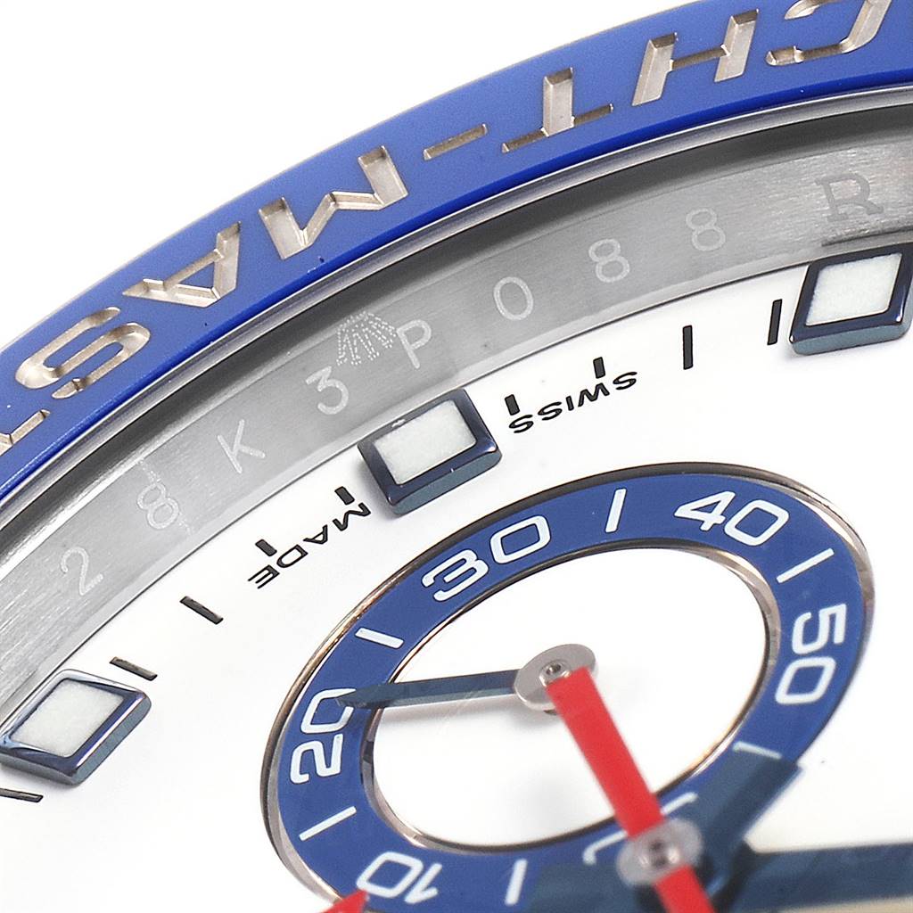 This close-up shot of the Rolex Yacht-Master 116680 Men
s Stainless Steel White Dial 116680 Men
s Stainless Steel White Dial showcases its bezel, markers, and part of the dial with blue and red accents.