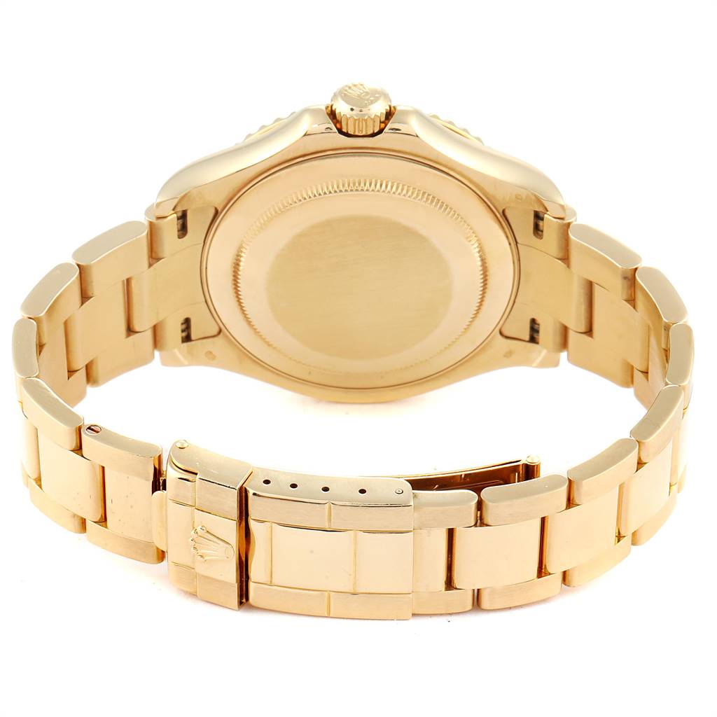 The image shows the back view of a Rolex Yacht-Master 16628 Men's Yellow Gold White Dial 16628 Men's Yellow Gold White Dial watch, including its gold case, bracelet, and clasp.