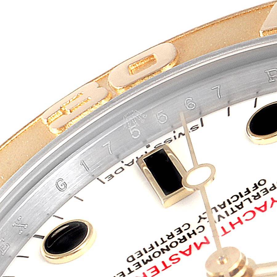 This close-up angle of the Rolex Yacht-Master 168623 Men's Steel and Gold (two tone) White Dial 168623 Men's Steel and Gold (two tone) White Dial watch showcases part of the bezel, dial, and hands.