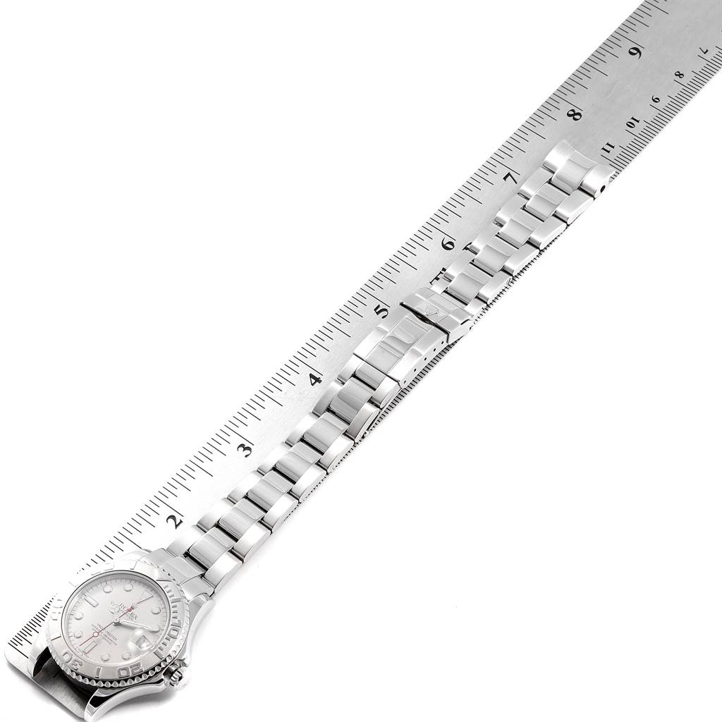 The Rolex Yacht-Master 168622 Men
s Stainless Steel Silver Dial 168622 Men
s Stainless Steel Silver Dial watch is shown from a top-down angle, with the face, bezel, and band visible alongside a ruler for scale.