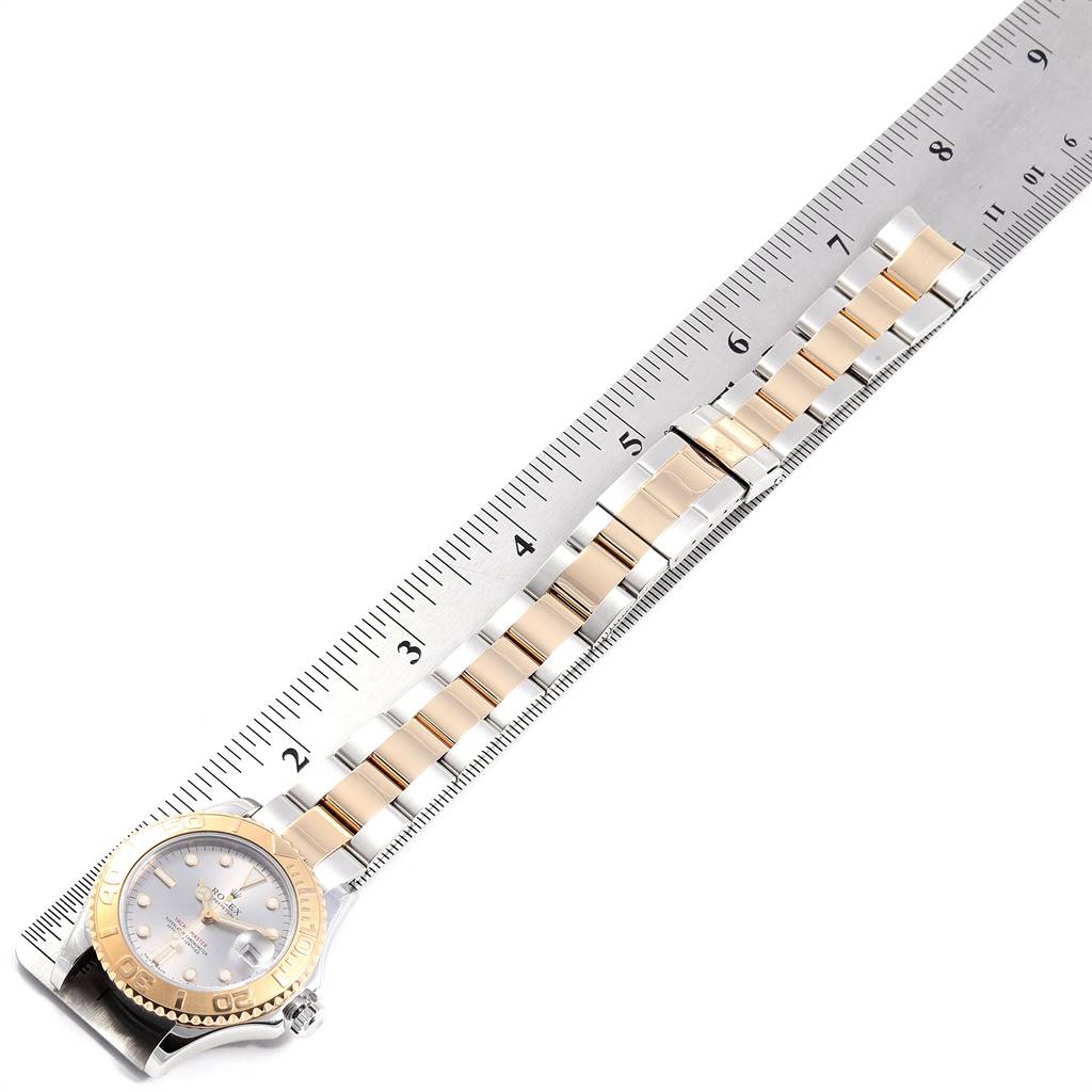 The Rolex Yacht-Master 168623 Men
s Steel and Gold (two tone) Grey Dial 168623 Men
s Steel and Gold (two tone) Grey Dial watch is shown from an overhead angle, focusing on the watch face and the entire bracelet beside a ruler.
