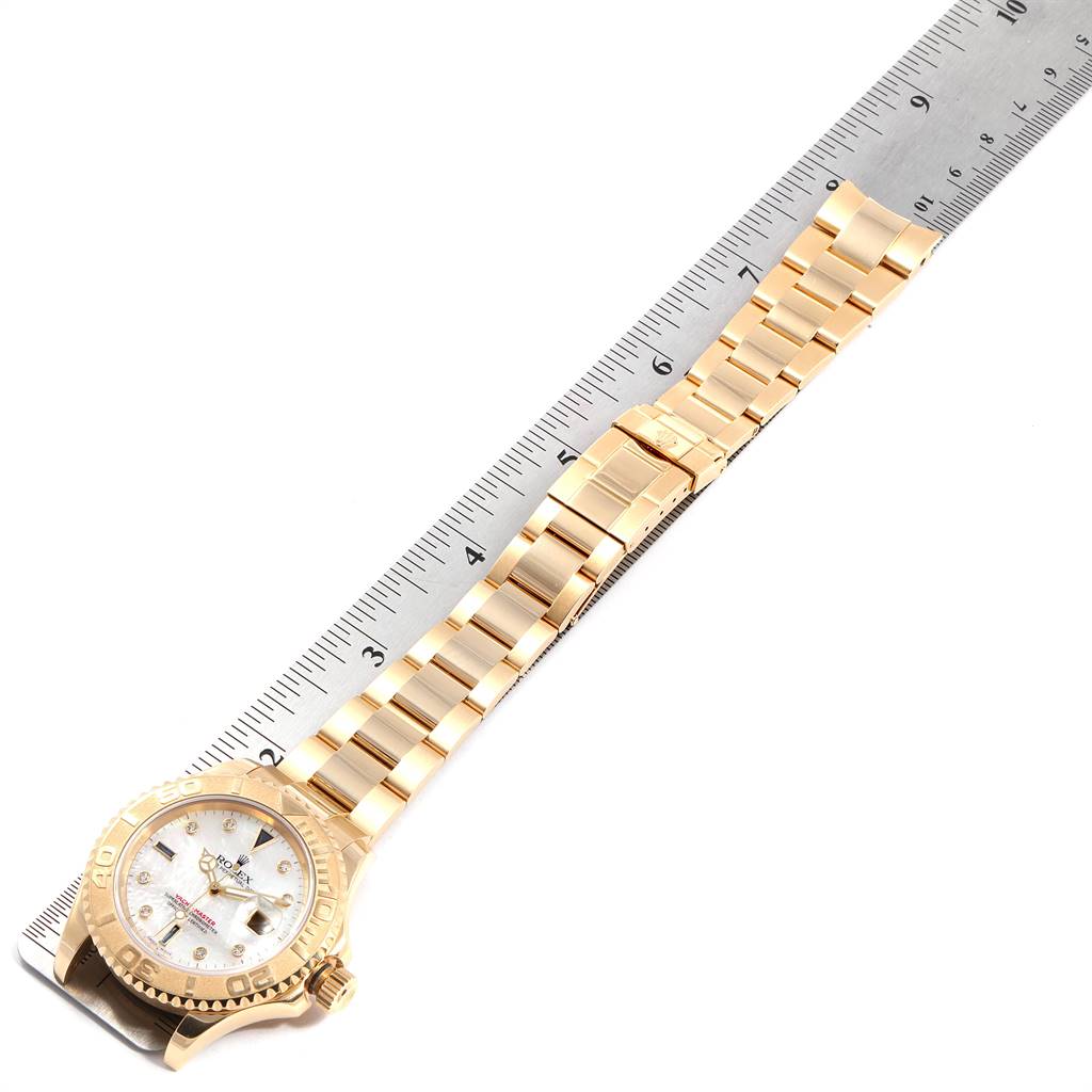 The image shows a top-down view of a Rolex Yacht-Master 16628 Men
s Yellow Gold Mother of Pearl Dial 16628 Men
s Yellow Gold Mother of Pearl Dial watch, including its dial, bezel, and full bracelet, with a ruler for scale.
