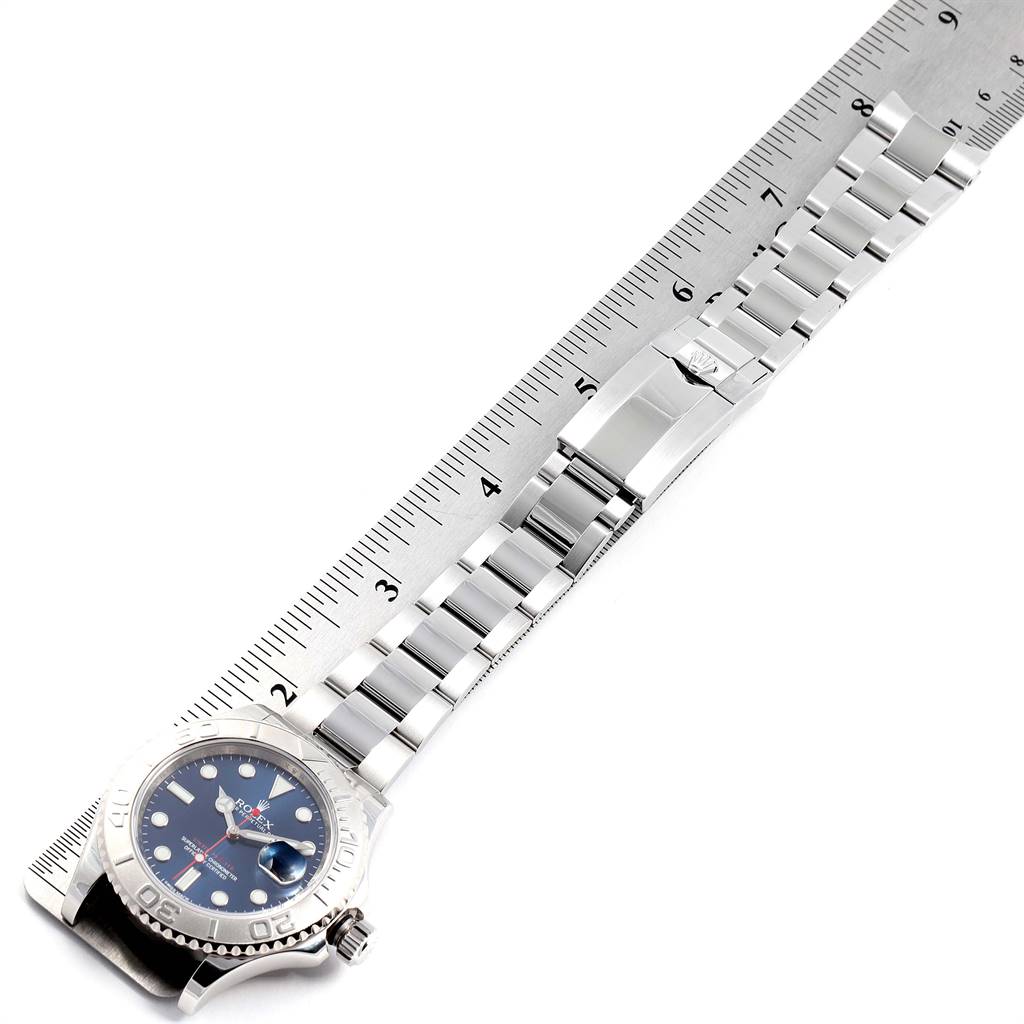 The Rolex Yacht-Master 116622 Men
s Stainless Steel Blue Dial 116622 Men
s Stainless Steel Blue Dial watch is displayed flat, highlighting its face, bracelet, clasp, and ruler for scale.