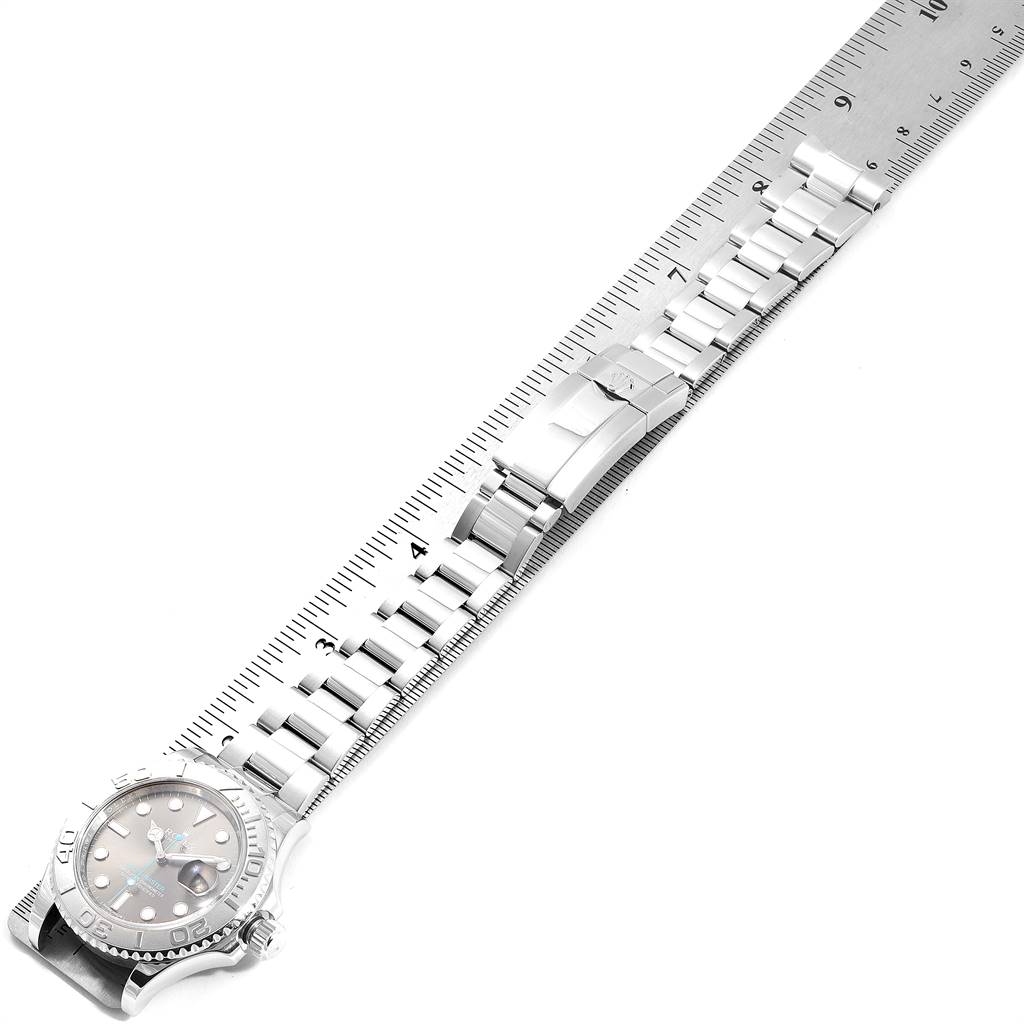 The image shows a Rolex Yacht-Master 116622 Men
s Stainless Steel Grey Dial 116622 Men
s Stainless Steel Grey Dial watch laid flat alongside a ruler, displaying the face, bracelet, and clasp from a top-down angle.