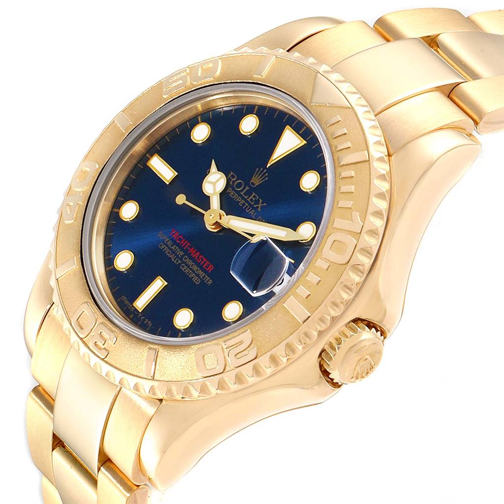 The image shows a side angle of the Rolex Yacht-Master 68628 Yellow Gold Blue Dial 68628 Yellow Gold Blue Dial watch, highlighting its gold bracelet, blue dial, and bezel.