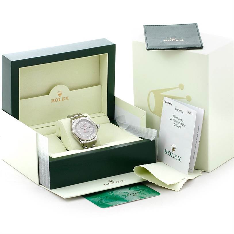 The Rolex Yacht-Master 16622 Men's Stainless Steel Silver Dial 16622 Men's Stainless Steel Silver Dial watch is displayed in an open box, accompanied by its warranty card, manual, and cleaning cloth.