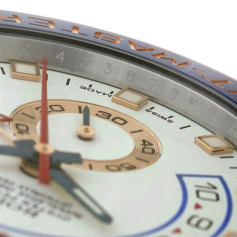 This close-up image of a Rolex Yacht-Master 116681 Men's Steel and Gold (two tone) White Dial 116681 Men's Steel and Gold (two tone) White Dial watch displays part of the dial, hands, and bezel at an angled view.
