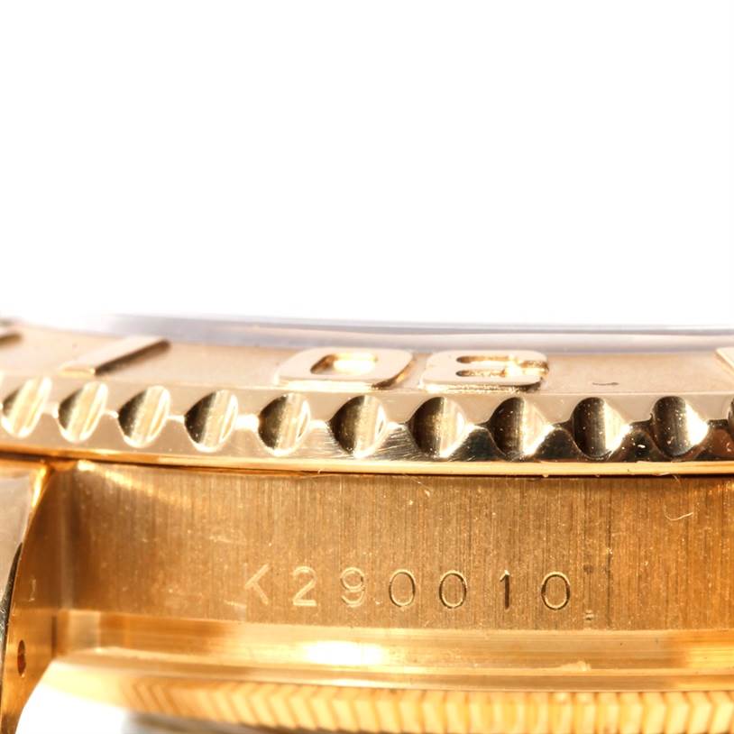 This close-up angle of the Rolex Yacht-Master 16628 Men's Yellow Gold White Dial 16628 Men's Yellow Gold White Dial shows the side of the gold bezel and part of the case, featuring a serial number.