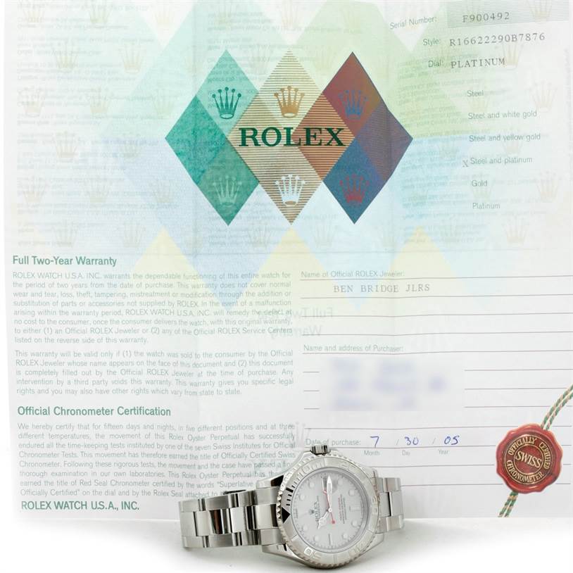 The image shows a Rolex Yacht-Master 16622 Men's Stainless Steel Silver Dial 16622 Men's Stainless Steel Silver Dial watch placed in front of the warranty certificate.