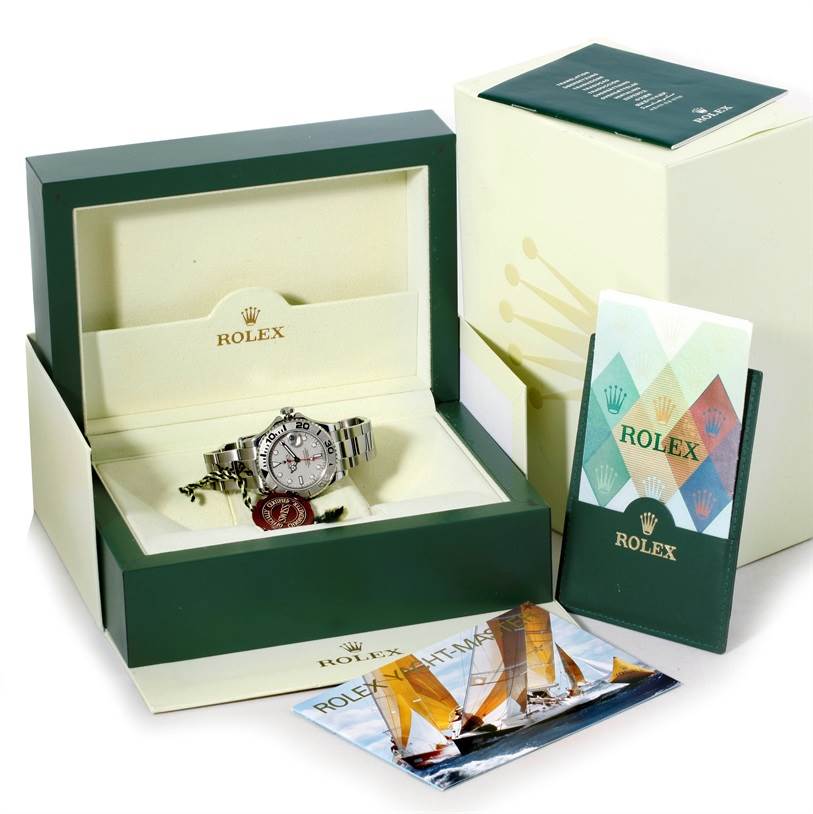 The image shows a Rolex Yacht-Master 168622 Stainless Steel Silver Dial 168622 Stainless Steel Silver Dial watch in its open green and cream box, with accompanying booklets and accessories scattered around.