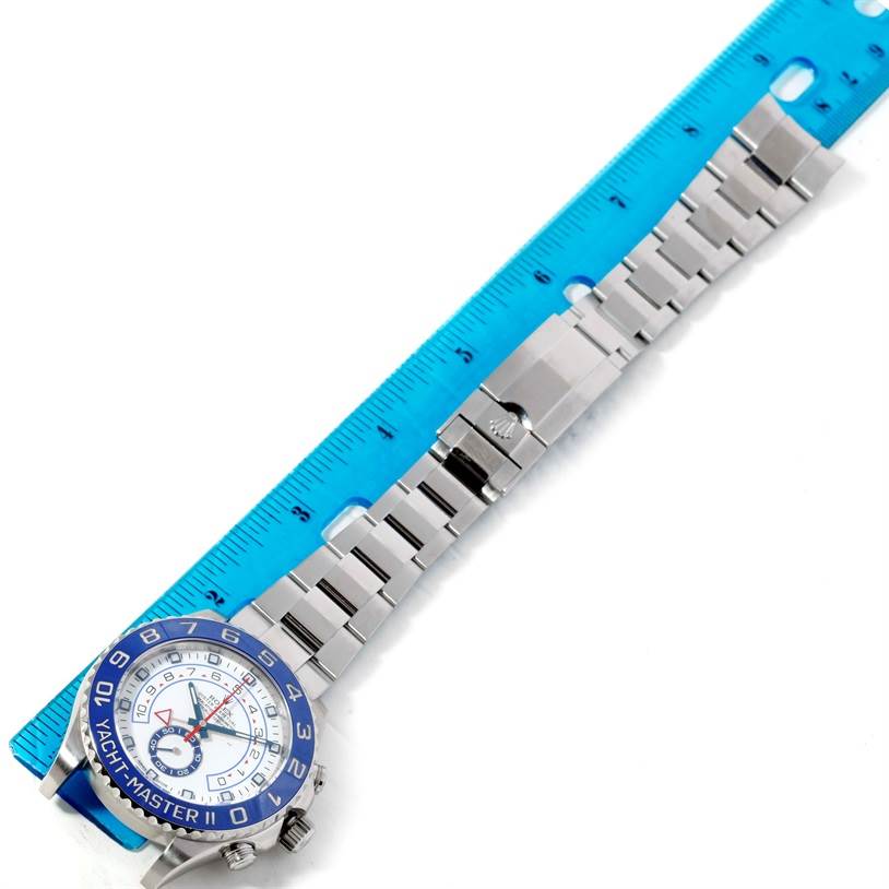 The Rolex Yacht-Master 116680 Men
s Stainless Steel White Dial 116680 Men
s Stainless Steel White Dial watch is shown from a flat angle, displaying the watch face, bezel, and full bracelet alongside a ruler for measurement.