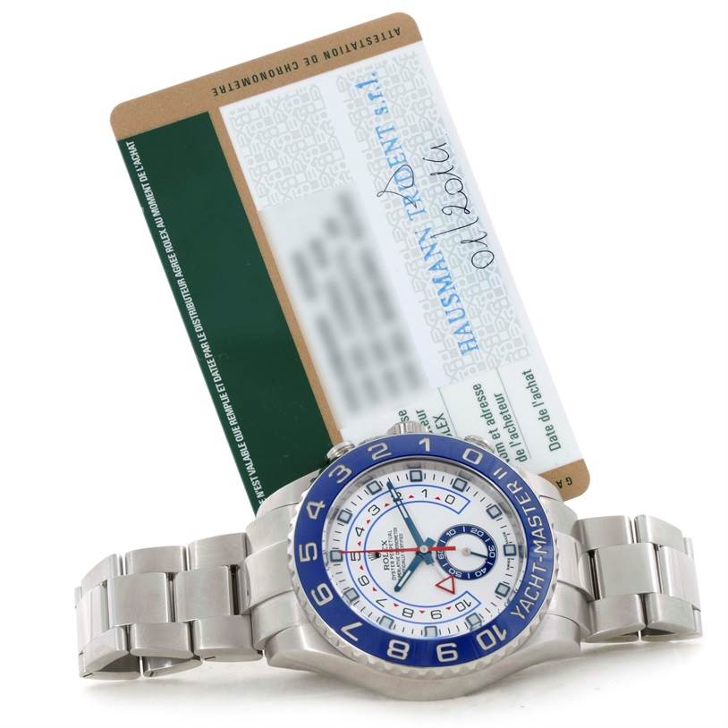 The image shows a Rolex Yacht-Master 116680 Men
s Stainless Steel White Dial 116680 Men
s Stainless Steel White Dial watch laid flat, highlighting its blue bezel and partially visible warranty card.