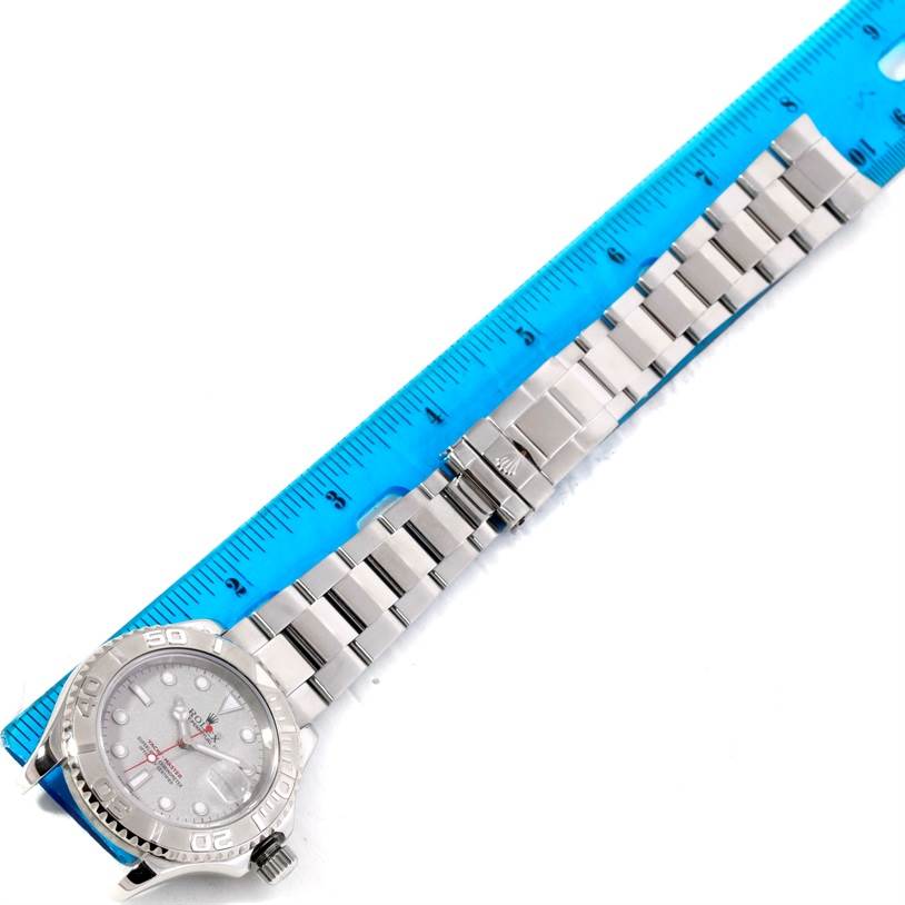 The image shows the Rolex Yacht-Master 16622 Men's Stainless Steel Silver Dial 16622 Men's Stainless Steel Silver Dial watch laid flat, highlighting its face and metal bracelet next to a blue ruler.