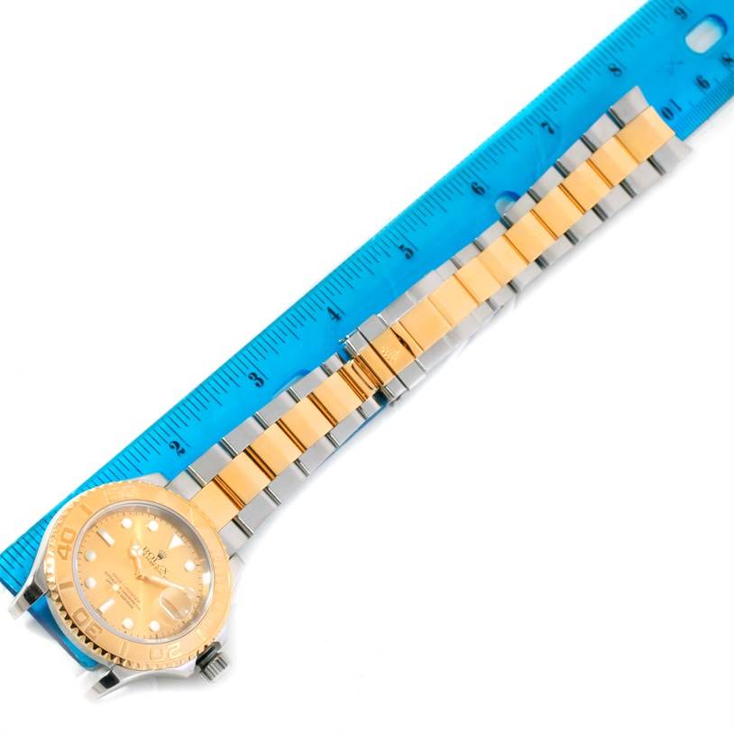 The image shows a Rolex Yacht-Master 16623 Men's Stainless Steel Champagne Dial 16623 Men's Stainless Steel Champagne Dial watch, focusing on the face, bezel, and full bracelet next to a blue ruler for scale.