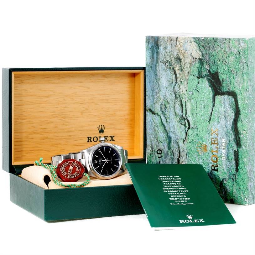 The Rolex Air-King 14000 Men's Stainless Steel Black Dial 14000 Men's Stainless Steel Black Dial watch is displayed in its box, along with tags and manuals, set against a nature-themed background.