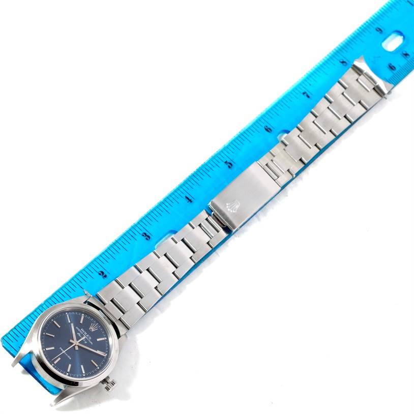The image shows a Rolex Air-King 14000 Men's Stainless Steel Blue Dial 14000 Men's Stainless Steel Blue Dial watch laid flat beside a blue ruler, displaying the face, bracelet, and clasp.