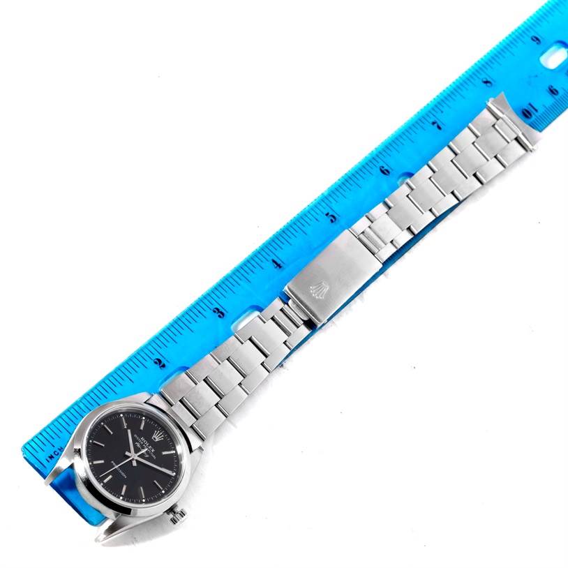 This image shows a Rolex Air-King 14000 Men's Stainless Steel Black Dial 14000 Men's Stainless Steel Black Dial watch laid flat next to a ruler, highlighting the face, bracelet, and clasp.