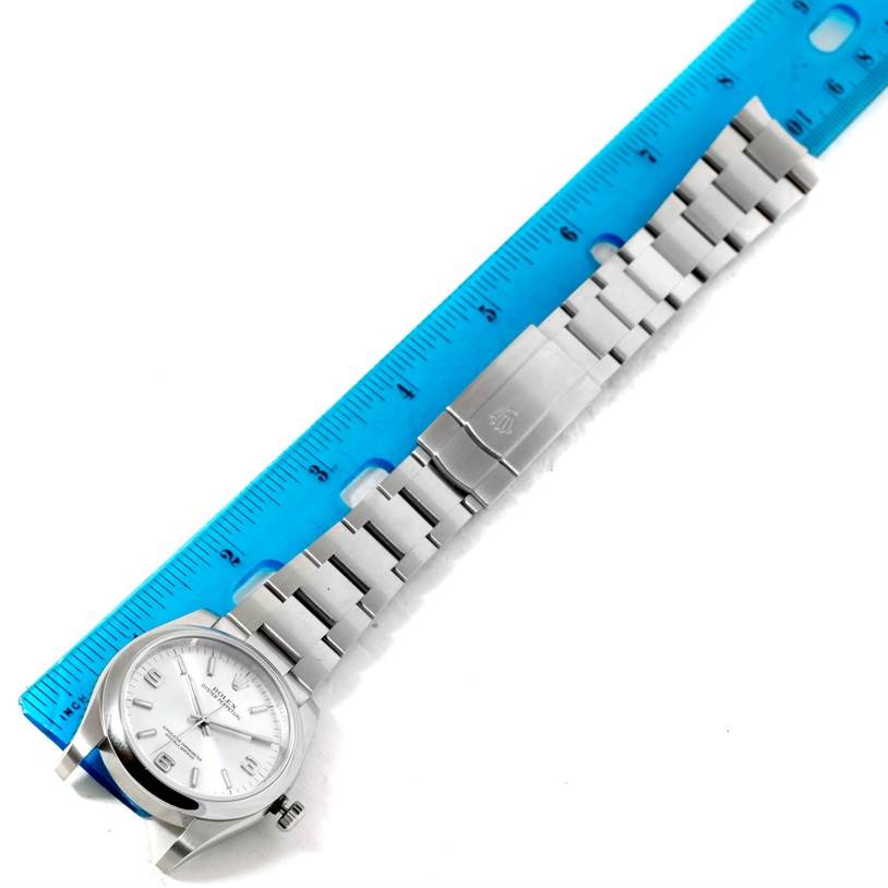 This image shows a Rolex Air-King 114200 Men's Stainless Steel Silver Dial 114200 Men's Stainless Steel Silver Dial watch laid flat, with the watch face, bracelet, and clasp visible next to a blue ruler for scale.