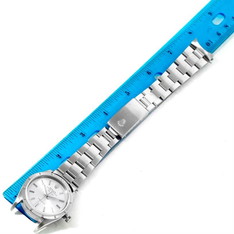 The Rolex Air-King 14010 Men's Stainless Steel Silver Dial 14010 Men's Stainless Steel Silver Dial watch is shown from a top-down angle, displaying the dial, bracelet, and clasp next to a ruler.