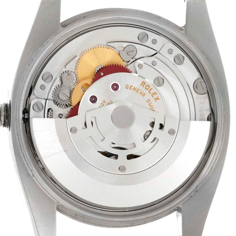 This image shows the internal mechanism of the Rolex Air-King 114200 Men's Stainless Steel Silver Dial 114200 Men's Stainless Steel Silver Dial watch, highlighting its gears and rotor from a back angle.