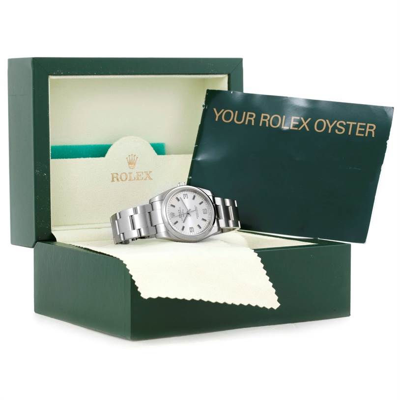 The Rolex Air-King 114200 Men's Stainless Steel Silver Dial 114200 Men's Stainless Steel Silver Dial watch is displayed at an angle in a green box, alongside a booklet titled "Your Rolex Oyster."