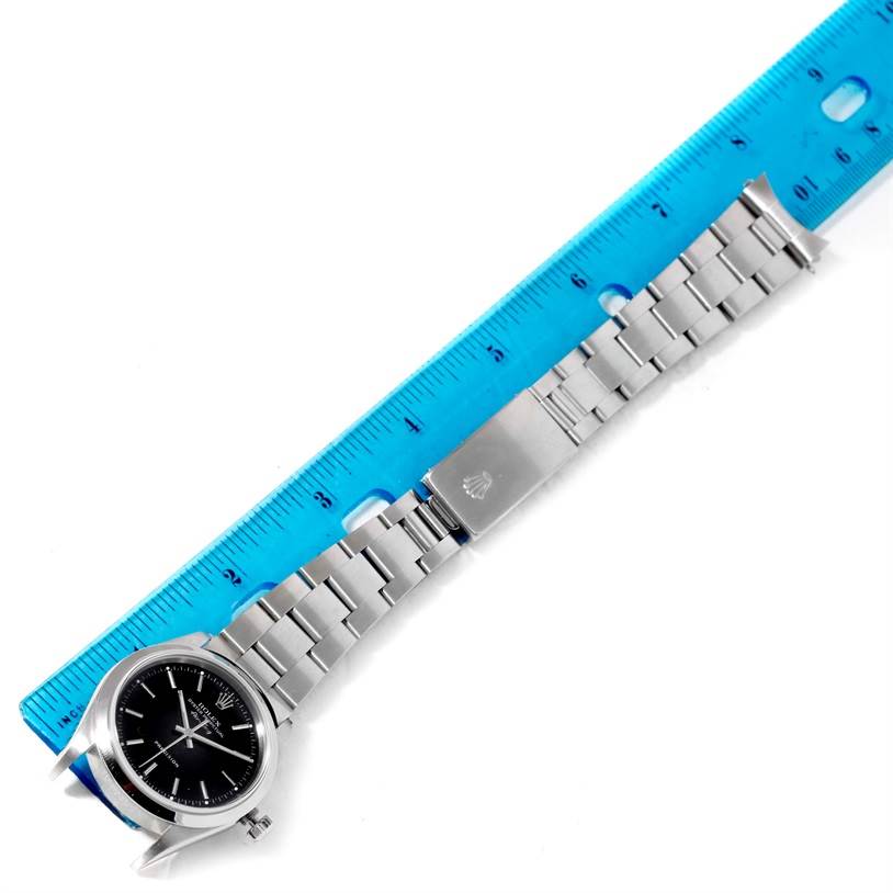 The Air-King Rolex watch is shown flat and straight, aligned next to a blue ruler with the face, bracelet, and clasp visible.