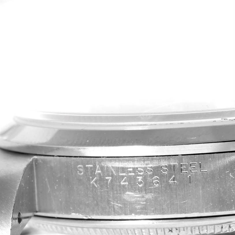 This image shows a close-up of the side of a Rolex Air-King 14000 Men's Stainless Steel Black Dial 14000 Men's Stainless Steel Black Dial watch, focusing on the stainless steel case with engraved serial numbers.