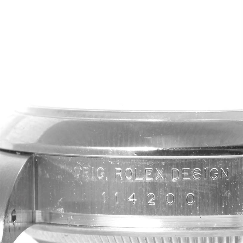 The image shows a close-up side view of the bezel and case of a Rolex Air-King 114200 Men's Stainless Steel Silver Dial 114200 Men's Stainless Steel Silver Dial watch, with engraved text and model number visible.