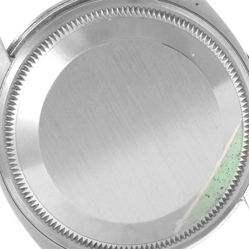 This is an image of the back case of a Rolex Air-King 114200 Men's Stainless Steel Silver Dial 114200 Men's Stainless Steel Silver Dial watch, viewed from a top-down angle.
