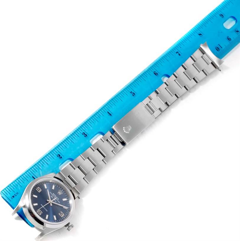 The Rolex Air-King 14000 Men's Stainless Steel Blue Dial 14000 Men's Stainless Steel Blue Dial watch is shown from a top view, focusing on the face, bracelet, and clasp, alongside a blue ruler for scale.