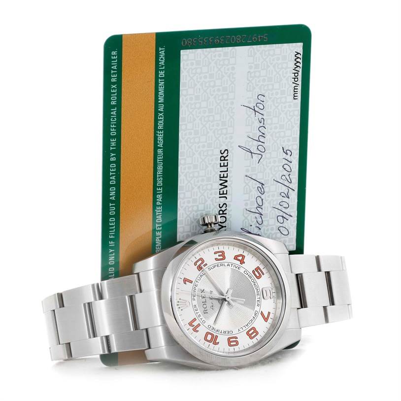 The Rolex Air-King 114200 Men's Stainless Steel Silver Dial 114200 Men's Stainless Steel Silver Dial watch is shown at a slight angle with its dial and bracelet visible, along with its authenticity card.