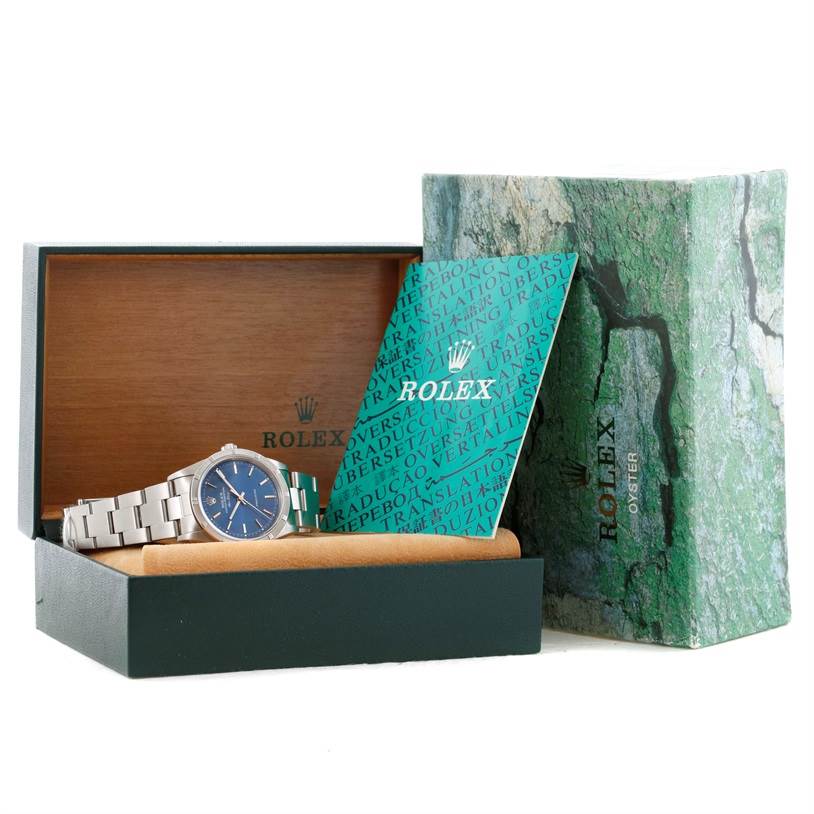 This image shows a Rolex Air-King 14010 Men's Stainless Steel Blue Dial 14010 Men's Stainless Steel Blue Dial watch at an angle inside an open box, accompanied by a booklet and outer packaging.