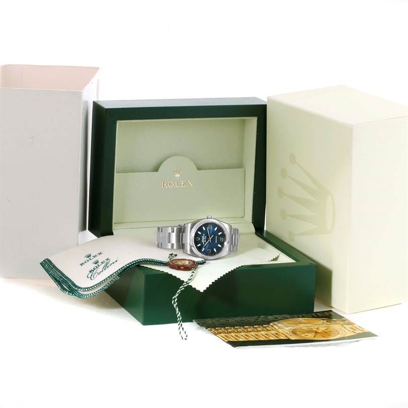 The Rolex Air-King 114200 Men's Stainless Steel Blue Dial 114200 Men's Stainless Steel Blue Dial watch is displayed front-facing in its open box with accessories.