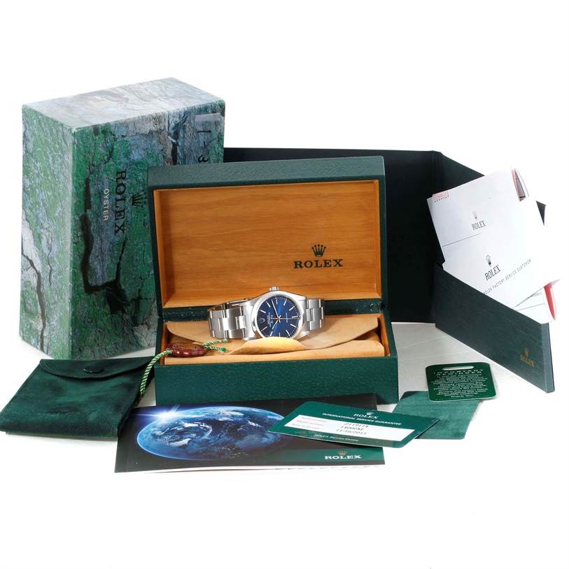 The Rolex Air-King 14000 Men's Stainless Steel Blue Dial 14000 Men's Stainless Steel Blue Dial watch is displayed in its box along with warranty cards, manuals, and original packaging accessories.