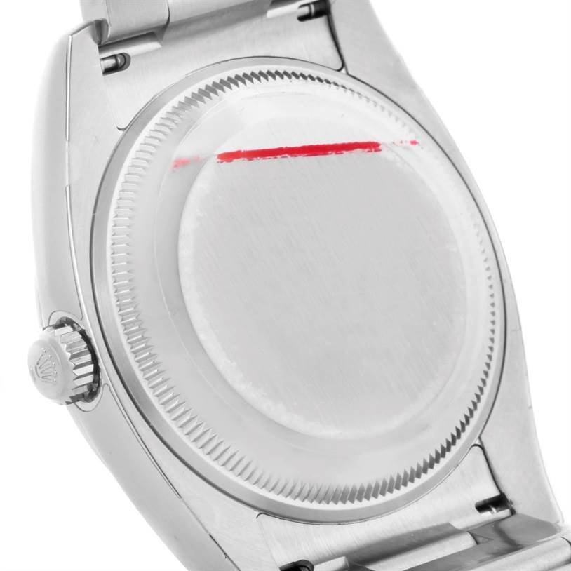 The image shows the back case and crown of a Rolex Air-King 114200 Men's Stainless Steel Blue Dial 114200 Men's Stainless Steel Blue Dial watch from a slightly angled perspective.