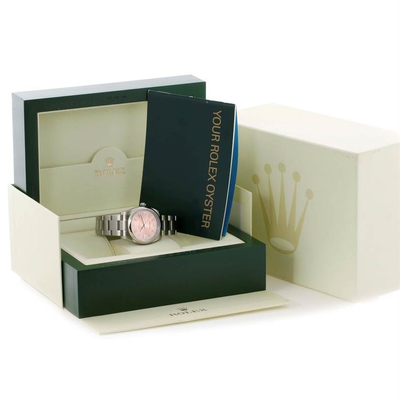 The Rolex Air-King 114200 Men's Stainless Steel Pink Dial 114200 Men's Stainless Steel Pink Dial watch is shown in an open box, along with a manual, viewed from a slightly elevated angle.