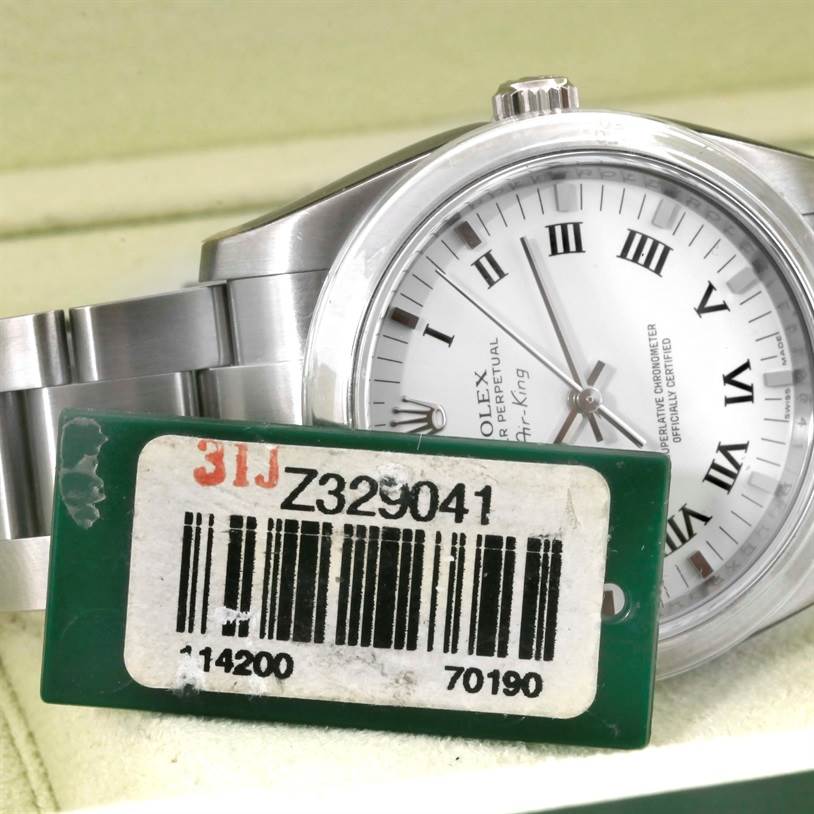 The image shows a side angle of the Rolex Air-King 114200 Men's Stainless Steel White Dial 114200 Men's Stainless Steel White Dial watch, displaying its silver bracelet, white Roman numeral dial, and the model tag.