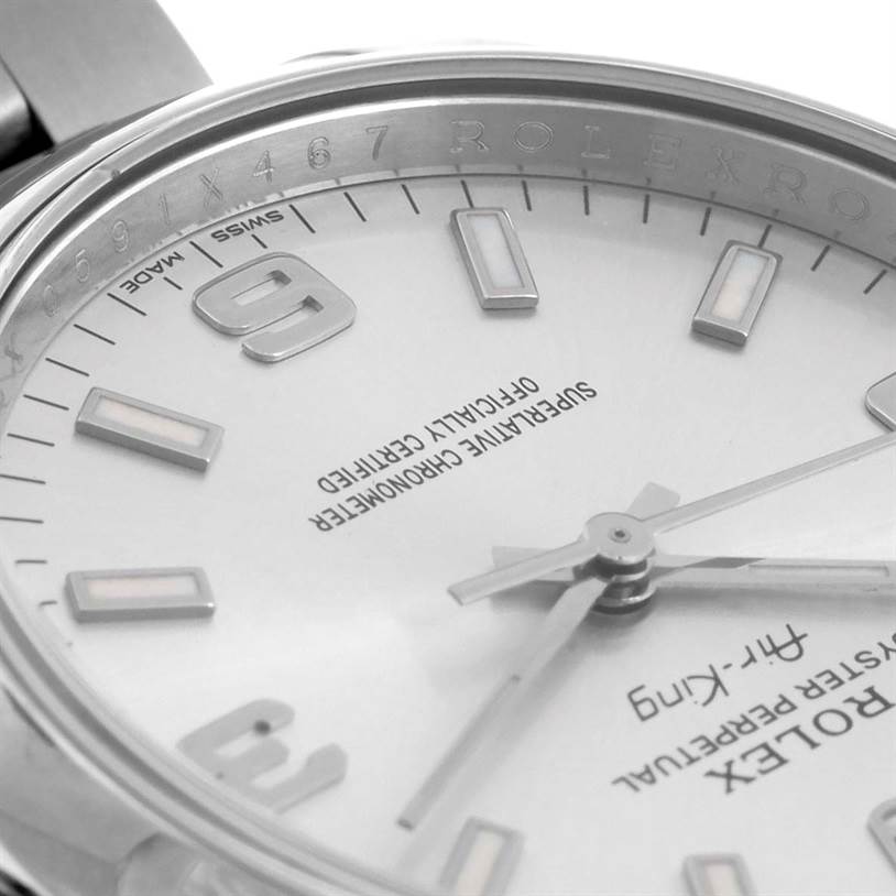 The image shows a close-up of the dial of a Rolex Air-King 114200 Men's Stainless Steel Silver Dial 114200 Men's Stainless Steel Silver Dial watch, focusing on the hands, markers, and part of the bezel with the brand engraving.