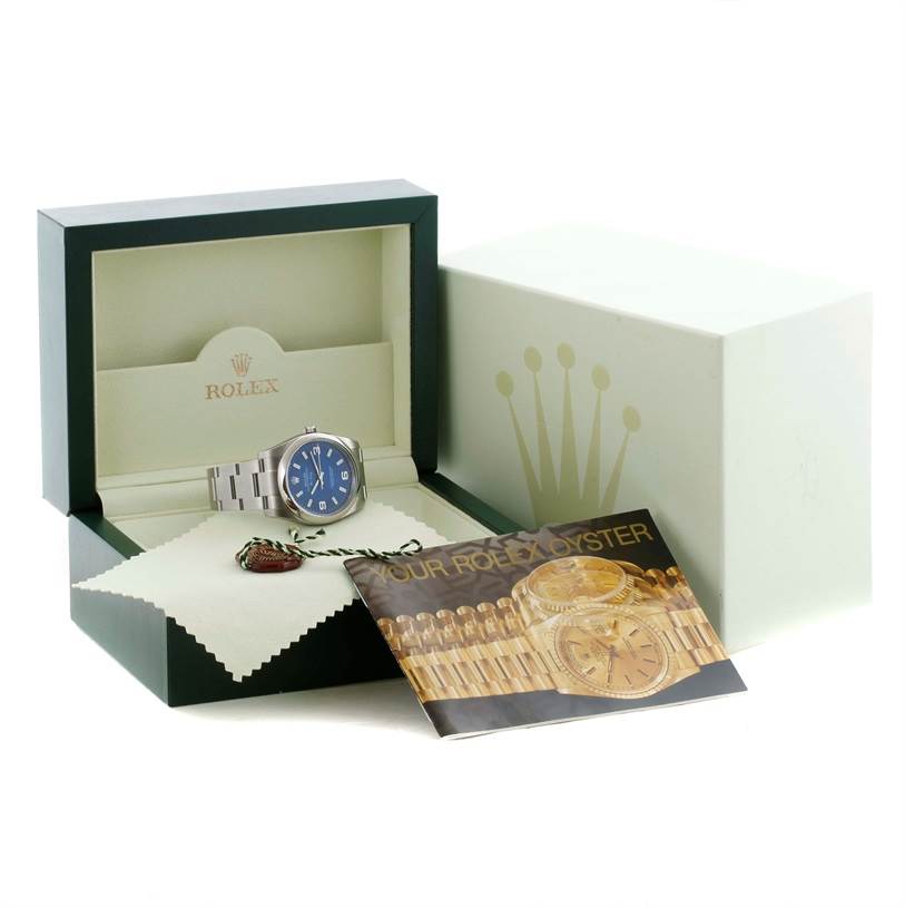 A Rolex Air-King 114200 Men's Stainless Steel Blue Dial 114200 Men's Stainless Steel Blue Dial watch is shown in its open display box along with a booklet and additional accessories.