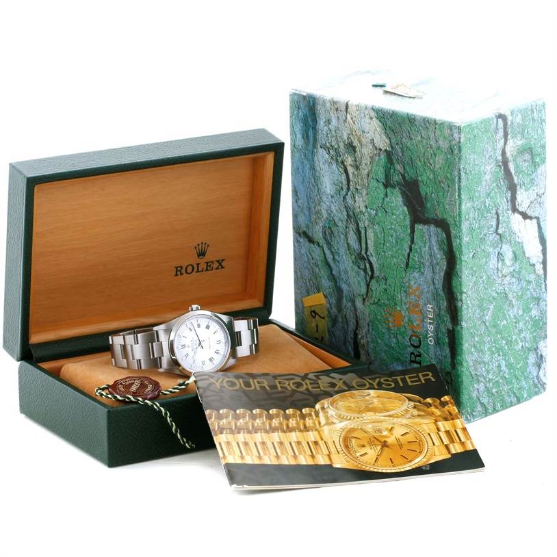 The Rolex Air-King 14000 Men's Stainless Steel White Dial 14000 Men's Stainless Steel White Dial watch is displayed in its open box, along with the packaging and an informational booklet.