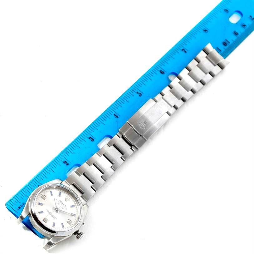 The image shows the full length of a Rolex Air-King 114200 Men's Stainless Steel Silver Dial 114200 Men's Stainless Steel Silver Dial watch, including the dial face and metal bracelet, next to a blue ruler.