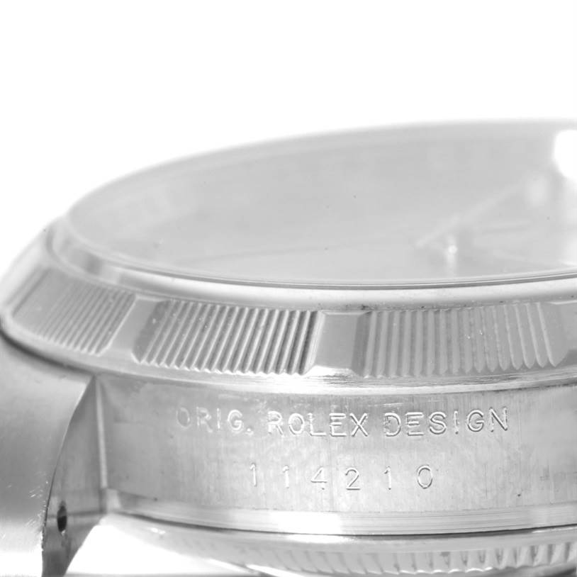This image shows a close-up of the side case and bezel of a Rolex Air-King 114210 Men's Stainless Steel Silver Dial 114210 Men's Stainless Steel Silver Dial watch, highlighting its engraved details.