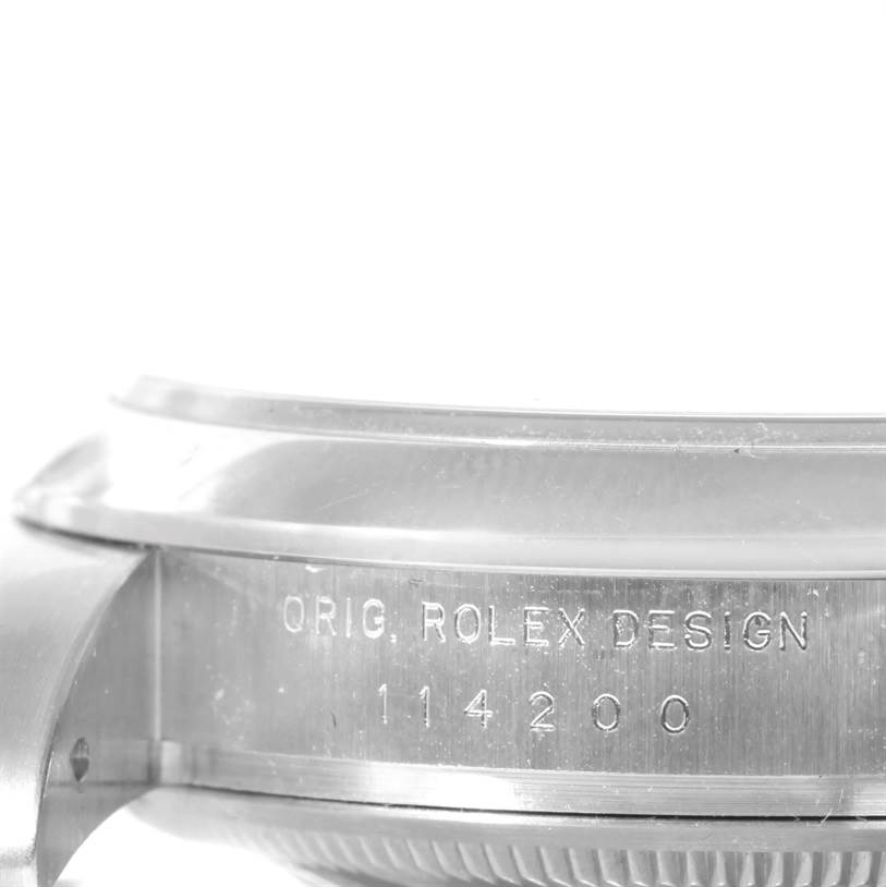 This is a close-up view of the side of a Rolex Air-King 114200 Men's Stainless Steel Silver Dial 114200 Men's Stainless Steel Silver Dial watch, showing "ORIG. ROLEX DESIGN" and the model number "114200."