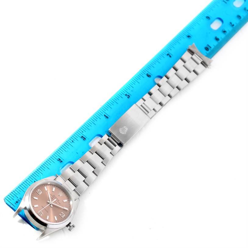 The Rolex Air-King 14000 Men's Stainless Steel Pink Dial 14000 Men's Stainless Steel Pink Dial watch is shown laid flat, displaying the face, bezel, bracelet, and clasp, with a ruler for scale.