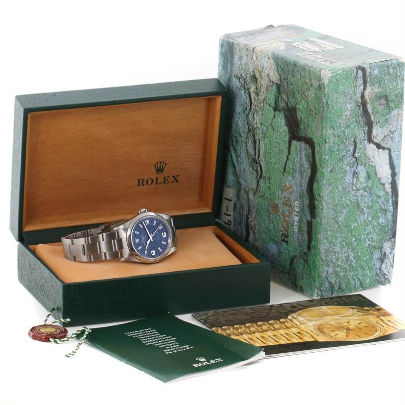 The image shows a Rolex Air-King 14000 Men's Stainless Steel Blue Dial 14000 Men's Stainless Steel Blue Dial watch in its open green box, alongside various manuals and a tag.