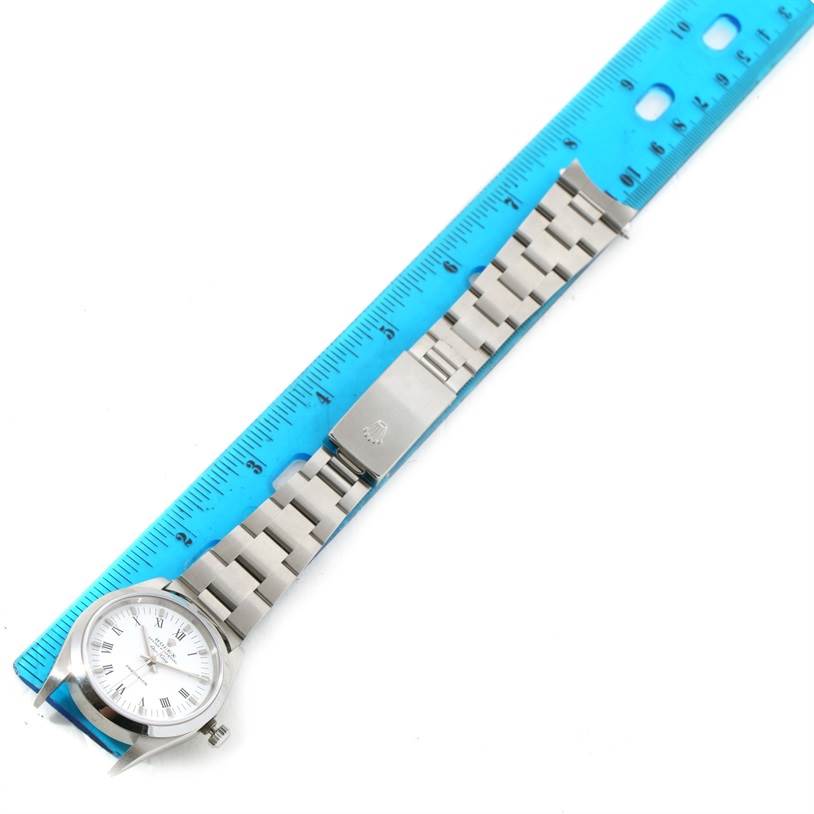 This image displays a Rolex Air-King 14000 Men's Stainless Steel White Dial 14000 Men's Stainless Steel White Dial watch laid flat, with the face, bracelet, and clasp visible alongside a blue ruler.